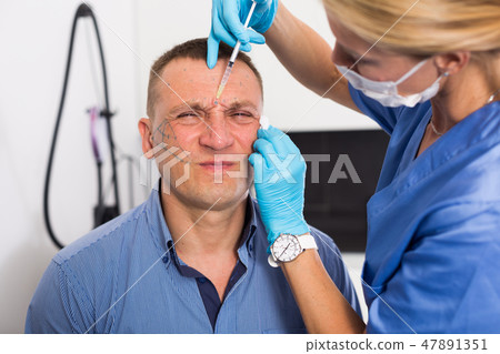 Female doctor is doing injection to patient in skin of face Female doctor is doing injection to patient in skin of face 47891351
