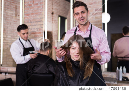 Man hairdresser discussing hairstyling with female client Man hairdresser discussing hairstyling with female client 47891486
