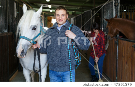 Cheerful man horse farm worker 47891579