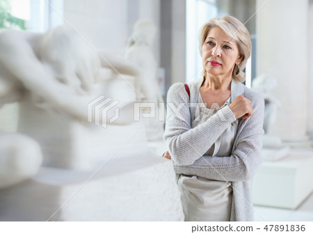 Adult female looking at artwork sculpture in the museum indoors 47891836