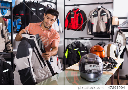 Active man is choosing new jacket for motorbike Active man is choosing new jacket for motorbike 47891904
