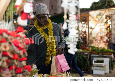 Man looking for New Year decorations Man looking for New Year decorations 47892328