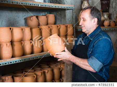 Elderly potter at ceramic workshop. Elderly potter at ceramic workshop. 47892331