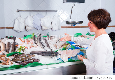 Woman choosing seafood in fish store 47892349