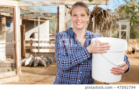 Woman feeding poultry 47892794
