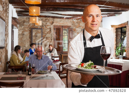 Waiter holding tray with dish 47892828