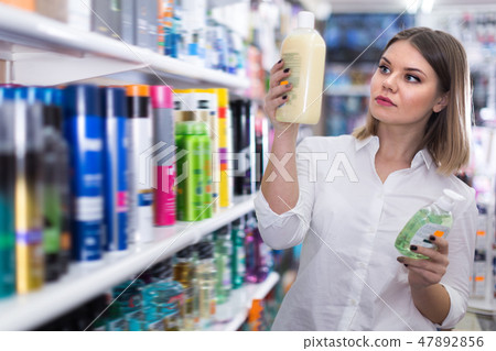 Nice girl choosing hair care treatments Nice girl choosing hair care treatments 47892856