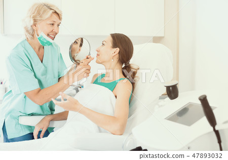 Cosmetologist consulting lady Cosmetologist consulting lady 47893032