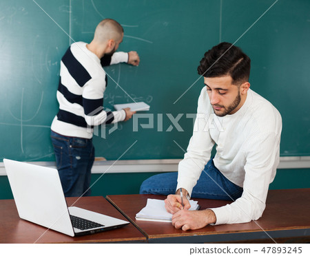 Two guys working on their student project Two guys working on their student project 47893245