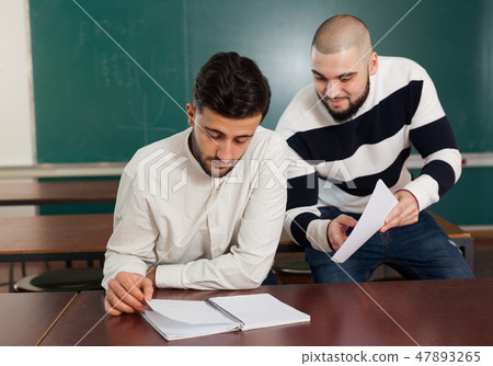 Students working with laptop at desk 47893265