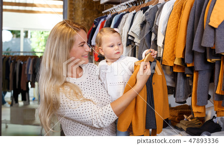 Mother and daughter choosing baby clothes Mother and daughter choosing baby clothes 47893336