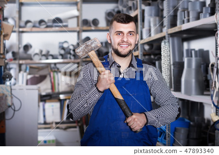 Smiling male builder showing constructing instruments Smiling male builder showing constructing instruments 47893340
