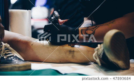 Tattoo artist drawing art on body Tattoo artist drawing art on body 47893684