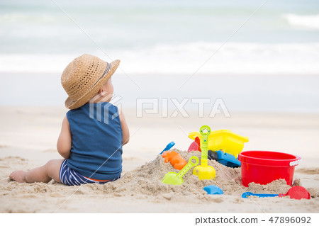 Asian baby boy playing sand on the beach,  47896092