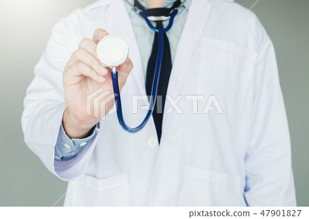 Doctor holding a stethoscope on background Doctor holding a stethoscope on background 47901827