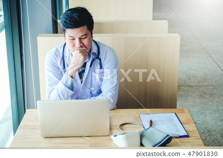 Doctor is working in office sitting, thinking Doctor is working in office sitting, thinking 47901830