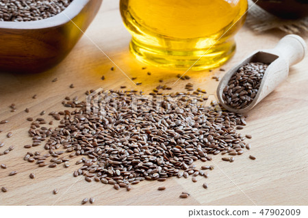 Flax seeds on a wooden table with flax seed oil Flax seeds on a wooden table with flax seed oil 47902009