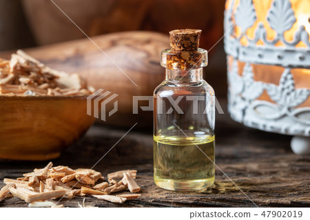 A bottle of cedar essential oil with cedar wood 47902019