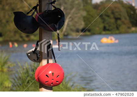 Wakeboard helmets hanging on a pole near the lake 47902020