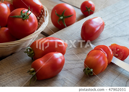 Slicing San Marzano tomatoes on a cutting board Slicing San Marzano tomatoes on a cutting board 47902031