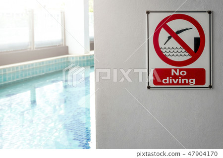 No diving sign at the poolside warning on blurred swimming pool No diving sign at the poolside warning on blurred swimming pool 47904170