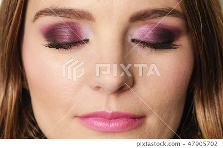 Woman closed eyes with violet dark shadows makeup 47905702