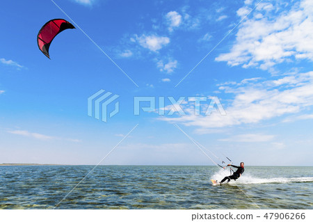Kitesurfing. Man rides a kite in the sea 47906266