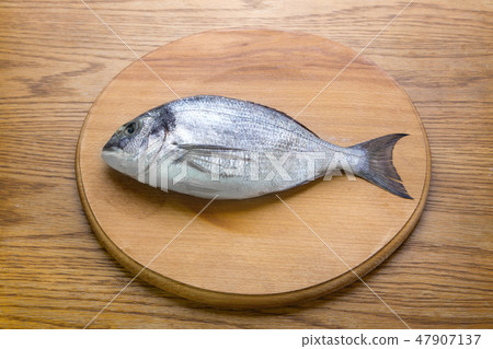 dorado fish on a wooden board top vew 47907137