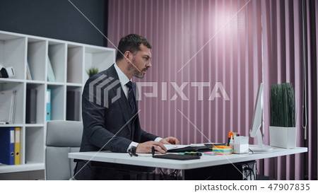 Businessman working in office, standing work at computer. Businessman working in office, standing work at computer. 47907835