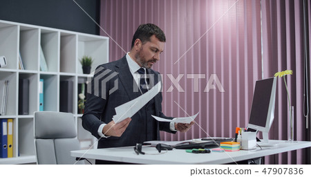Businessman working in office, standing work at computer. Businessman working in office, standing work at computer. 47907836