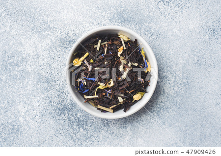Tea leaves for brewing in bowl on a gray backgroun 47909426