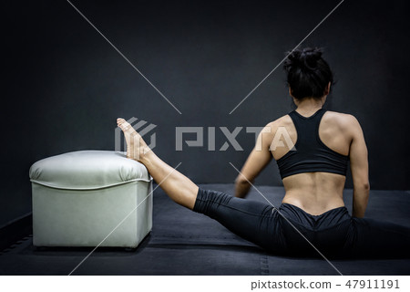 Asian girl stretching leg with chair in gym 47911191