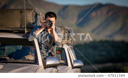Asian photographer taking photo on car window 47911394