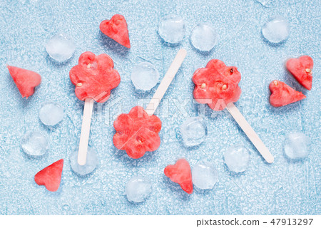 Popslices of fresh watermelon and ice on blue 47913297