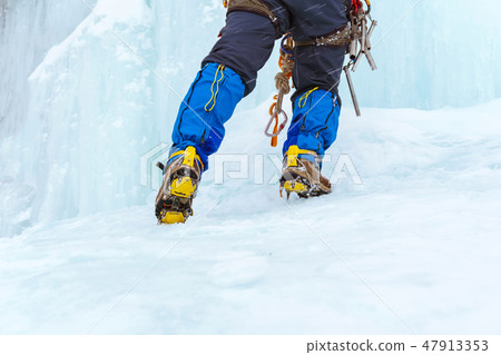 climber's feet climbing the icy slope 47913353
