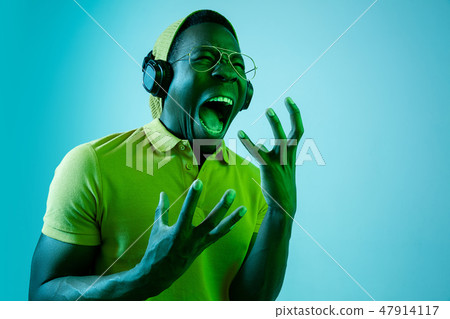 The young handsome hipster man listening music with headphones The young handsome hipster man listening music with headphones 47914117