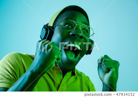 The young handsome hipster man listening music with headphones The young handsome hipster man listening music with headphones 47914152