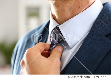Male arm in blue suit set tie closeup Male arm in blue suit set tie closeup 47914532