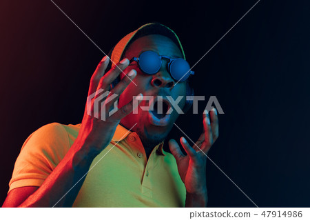 The young handsome hipster man listening music with headphones The young handsome hipster man listening music with headphones 47914986
