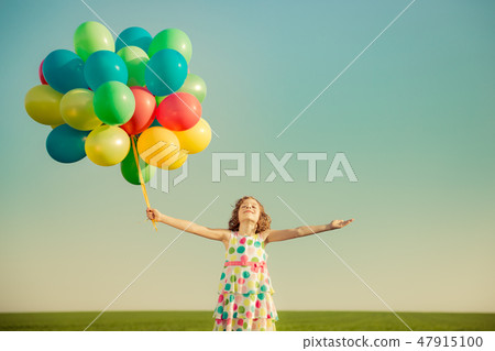 Happy child playing outdoors in spring field 47915100