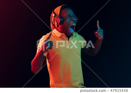 The young handsome hipster man listening music with headphones The young handsome hipster man listening music with headphones 47915438