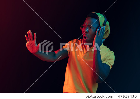 The young handsome hipster man listening music with headphones The young handsome hipster man listening music with headphones 47915439