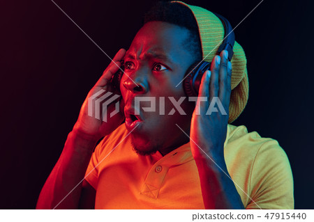 The young handsome hipster man listening music with headphones The young handsome hipster man listening music with headphones 47915440