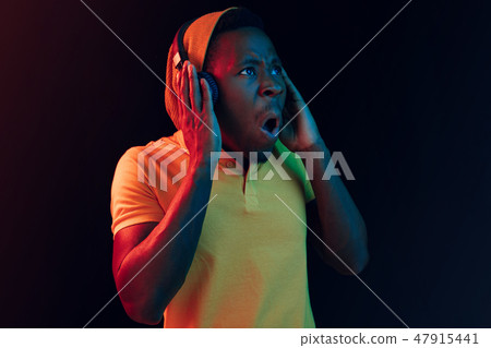The young handsome hipster man listening music with headphones The young handsome hipster man listening music with headphones 47915441