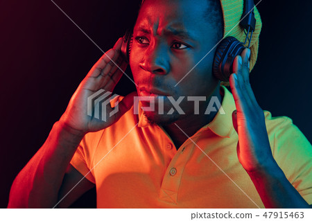 The young handsome hipster man listening music with headphones The young handsome hipster man listening music with headphones 47915463