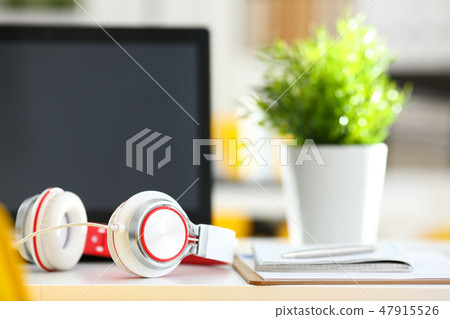 Empty remote office workplace with laptop and headset Empty remote office workplace with laptop and headset 47915526