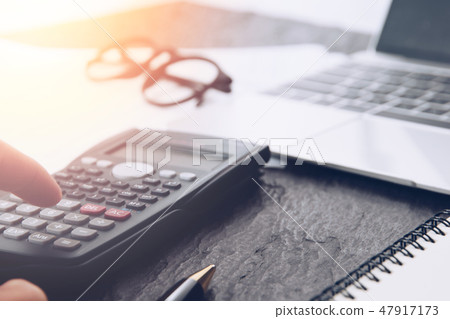 Financial accounting analysis Close up of hand counting on calculator in office desk 47917173