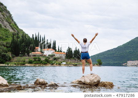 woman standing on cliff and looking at sea 47917286