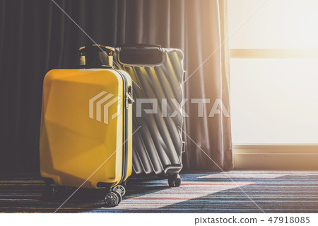 Suitcase Luggage bag in the bedroom with open curtain see sunrise light Suitcase Luggage bag in the bedroom with open curtain see sunrise light 47918085