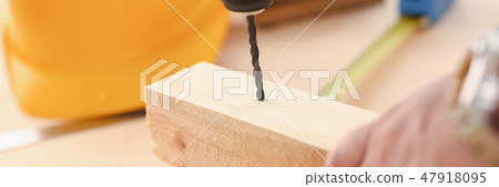 Arms of worker using electric drill 47918095